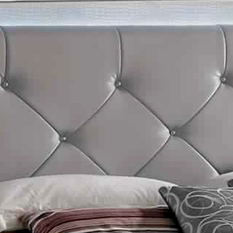 Un lit king-size texturé beige avec des garnitures argentées.