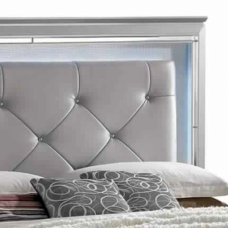 Un lit king-size texturé beige avec des garnitures argentées.